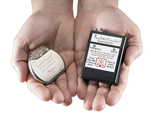 Two hands holding the two parts of the Guardian cardiac monitoring device.