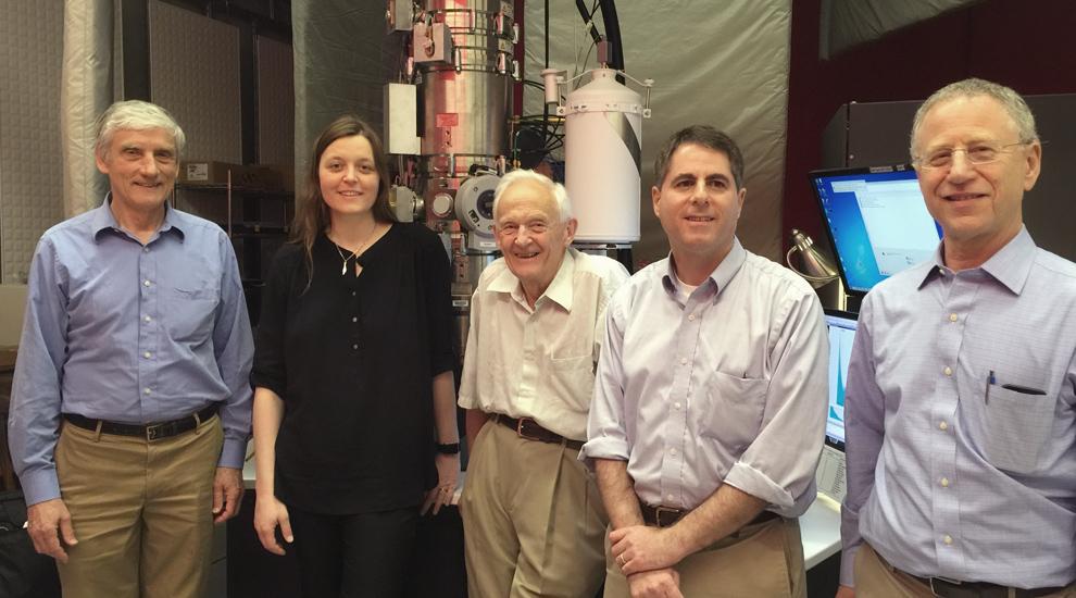 Lena and four male professors stand in front of the elecron microcope