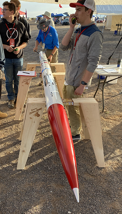 Sam Noles (right) with Cornell's rocket at the 2022 Spaceport America Cup in New Mexico.